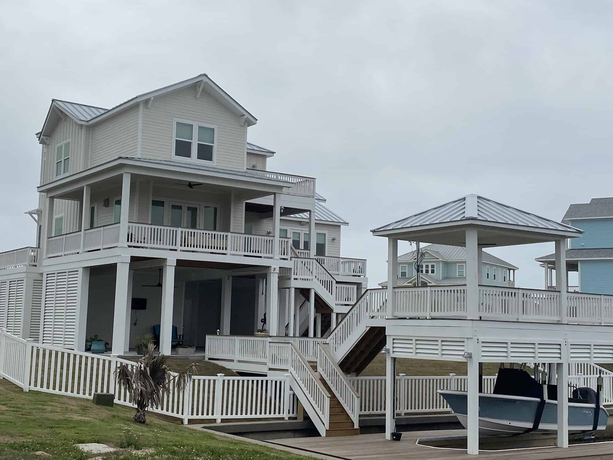 Rear porches and a covered boat lift on the canal at a Kai Custom Homes build in Sunset Cove, Galveston